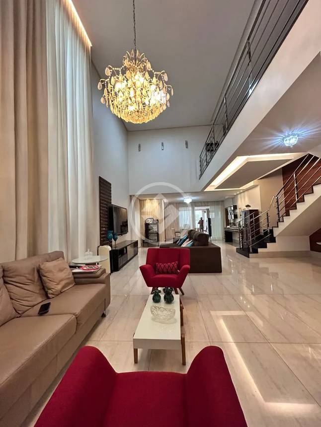 Sala de estar com sofá, mesa e luminária, além de iluminação embutida no Alphaville Araguaia