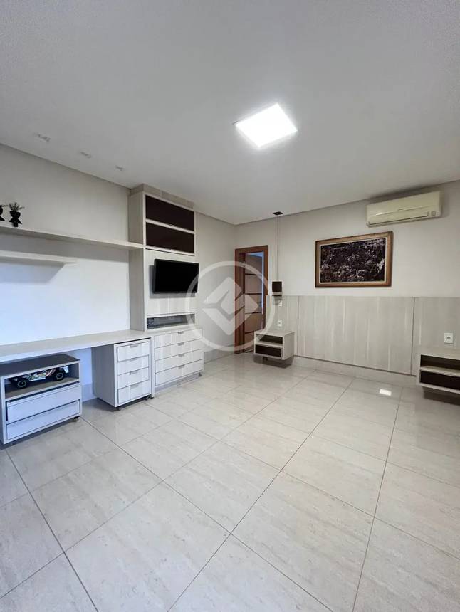 Sala de estar com televisão e armário, além de iluminação embutida