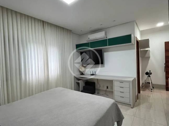 Sala de estar com painel de televisão, luminária e tapete, além de iluminação embutida