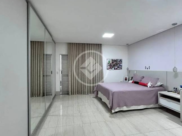Sala de estar com espelho e luminária, além de iluminação natural e revestimento claro