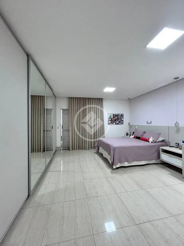 Sala de estar com espelho e luminária, além de iluminação natural e revestimento claro