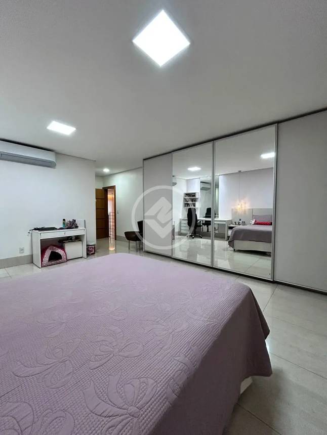 Ambiente interno com espelho e cama, além de iluminação embutida