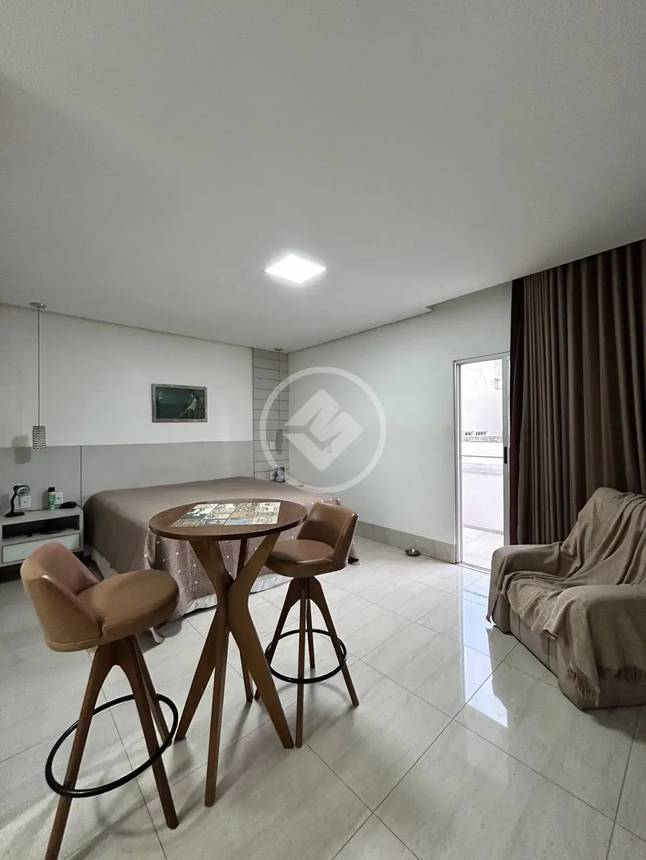 Sala de estar com mesa e cadeiras, além de iluminação embutida