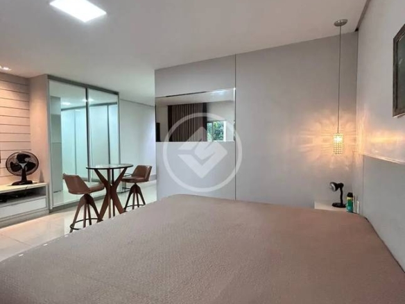Sala de estar com mesa e luminária, além de iluminação embutida