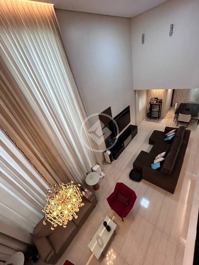 Sala de estar com sofá, mesa e luminária no Alphaville Araguaia